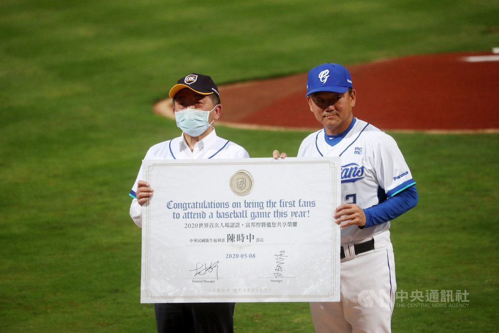 中央流行疫情指揮中心指揮官陳時中(左)8日晚間到新莊棒球場,參與領先全球開放球迷入場觀戰的中職賽事,富邦悍將隊總教練洪一中(右)並頒發「2020世界首次入場認證書」給陳時中作紀念。中央社記者吳家昇攝 109年5月8日