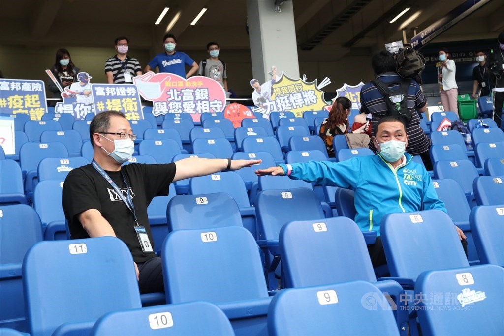 中華職棒8日起每場賽事開放1000名觀眾進場,新北市長侯友宜(前右)特別於開放首日前往新莊棒球場,了解球迷座位規劃,並與中職會長吳志揚(前左)試坐,伸手量測間隔距離。中央社記者吳家昇攝 109年5月8日