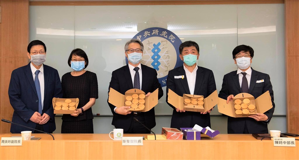 中研院11日在臉書上PO出衛福部長陳時中(右2)與中研院長廖俊智(右3)等人合照,他們手拿30個紅豆餅,預祝台灣邁入30天本土零確診案例。(圖取自facebook.com/sinicaedu)