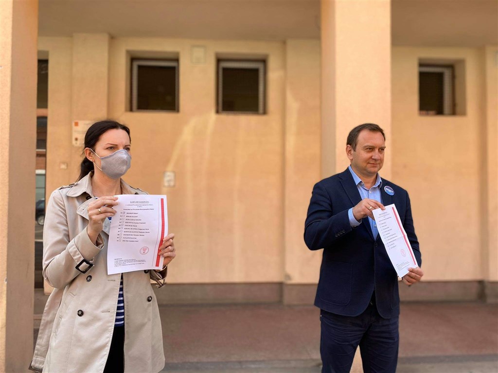 武漢肺炎疫情引爆波蘭政治危機,總統大選10日雖如期舉行,但投票所關閉、投票率掛零。左派國會議員特瑞拉(右)在一所通常被當成投票所的學校秀出自製選票,問說他們為何不能投票。(圖取自twitter.com/poselttrela)
