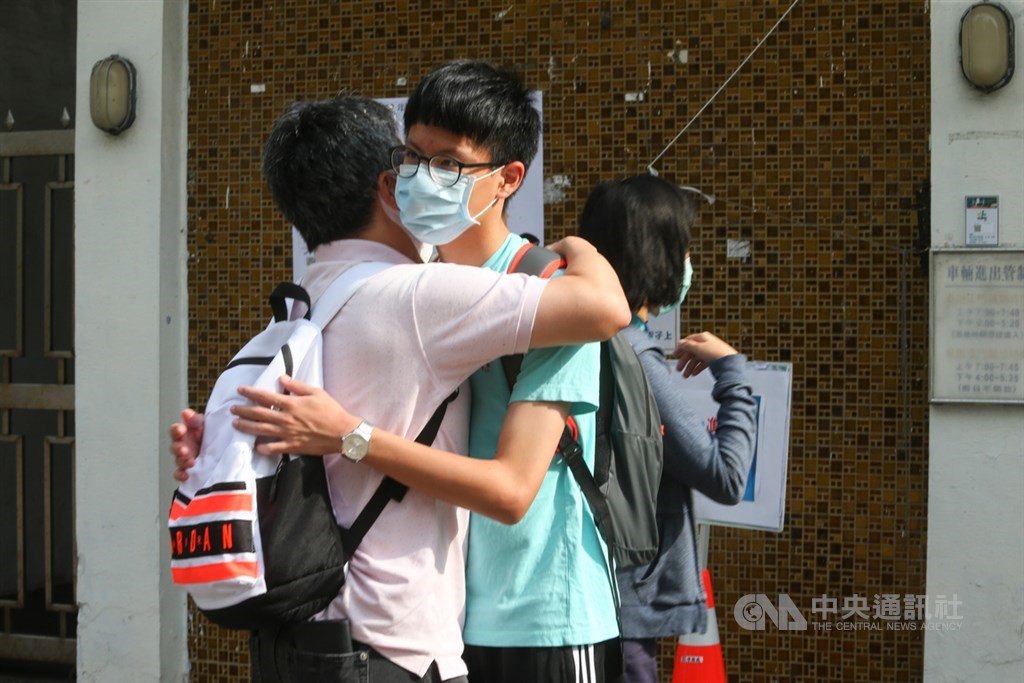 國中教育會考16日登場,因應2019冠狀病毒疾病(COVID-19,俗稱武漢肺炎)疫情,首度不開放陪考,親友在考場門口為考生加油打氣。中央社記者謝佳璋攝 109年5月16日