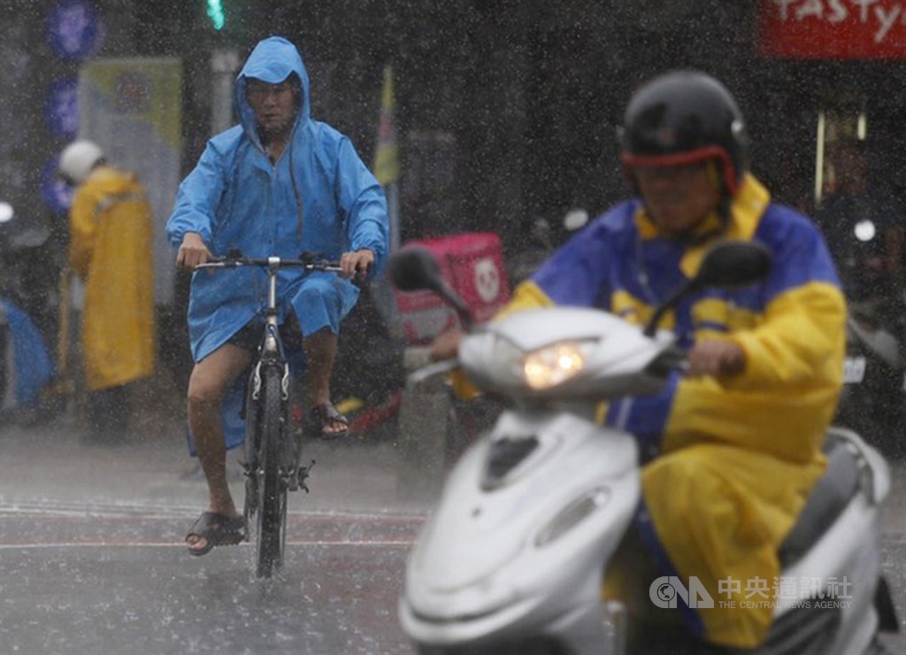 受到滯留鋒面及西南氣流影響,氣象局對多地發出豪大雨特報,高雄街頭民眾在雨中騎腳踏車。中央社記者董俊志攝 109年5月21日