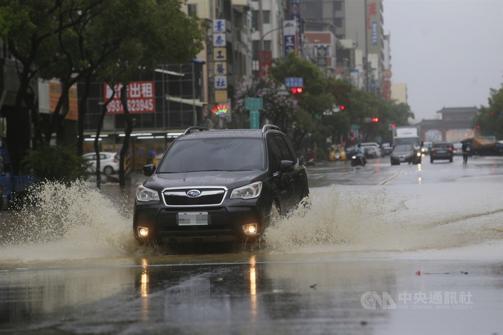受滯留鋒面及西南氣流影響,高雄市區22日下起滂沱大雨,鹽埕區七賢三路一帶道路積淹水,民眾開車疾駛而過,水花四濺。中央社記者董俊志攝 109年5月22日