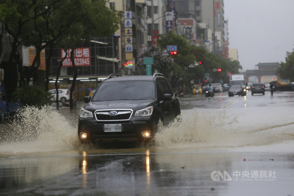 受滯留鋒面及西南氣流影響,高雄市區22日下起滂沱大雨,鹽埕區七賢三路一帶道路積淹水,民眾開車疾駛而過,水花四濺。中央社記者董俊志攝 109年5月22日