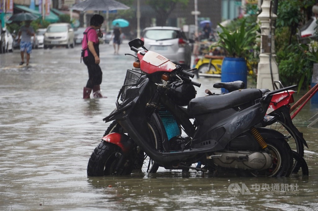 受滯留鋒面及西南氣流影響,高雄市區22日下起滂沱大雨,鹽埕區七賢三路一帶道路積淹水約到半個輪胎。中央社記者董俊志攝 109年5月22日
