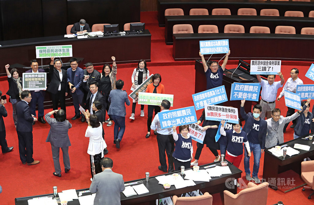 立法院會22日三讀通過農民退休儲金條例,關鍵條文是農民與政府的提繳比率,最後表決通過民進黨團版修正動議,農民提繳比率基準為勞工每月基本工資的10%範圍內自行決定,政府則1比1相對提繳。國民黨立法院黨團舉牌抗議,表示提繳比率要採1比1.5才對農民有保障。中央社記者裴禛攝 109年5月22日