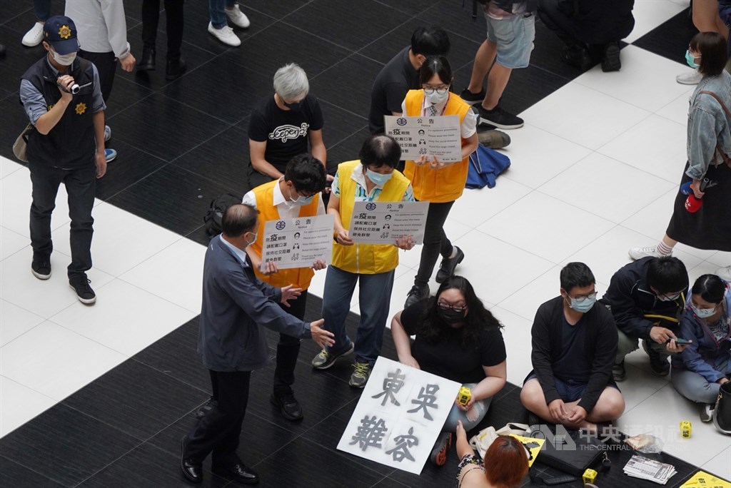台北車站大廳因疫情影響禁止群聚、席地而坐,疫情後能否再開放引發各界討論。有網友23日中午發起坐爆台北車站活動,表達希望開放立場,台鐵工作人員現場舉牌柔性勸離,呼籲防疫期間避免群聚,保持社交距離。中央社記者徐肇昌攝 109年5月23日