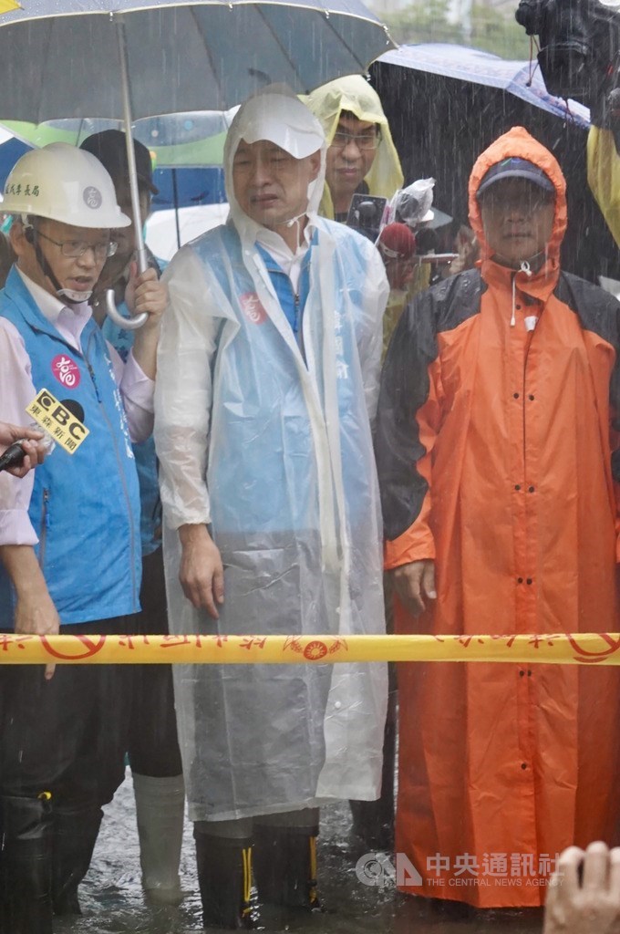 高雄地區22日大雨肆虐,多個行政區積淹水,高雄市長韓國瑜(中)22日下午冒雨到鹽埕區七賢路及興華街一帶視察。中央社記者董俊志攝 109年5月22日
