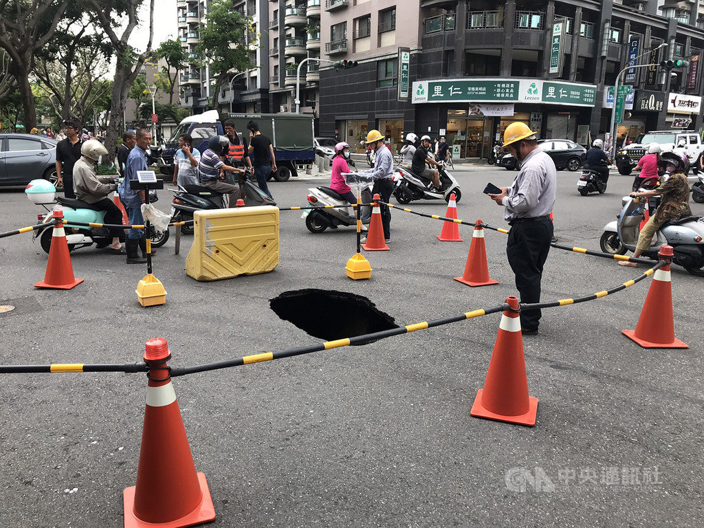 高雄市水利局24日下午接獲通報,英明路、英祥街交叉口路面有寬約2.3公尺、長約3.3公尺,深度約1.8公尺的坑洞,附近居民擔心路面掏空擴大危及公共安全於是報警,警方在現場豎立交通錐,並進行交通管制,同時通報有關單位搶修。(高雄市水利局提供)中央社記者程啟峰傳真 109年5月24日