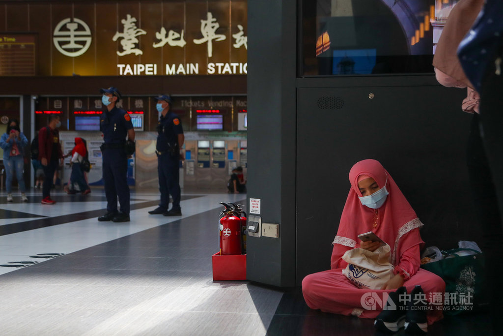 台鐵為防疫,自2月底開始禁止在台北車站大廳席地而坐及群聚,近來更傳出將研擬永久禁坐,引發爭議;24日適逢穆斯林開齋節,不少移工朋友現身北車,警方派員在場維持秩序,一名移工改坐在外圍角落。中央社記者王騰毅攝 109年5月24日