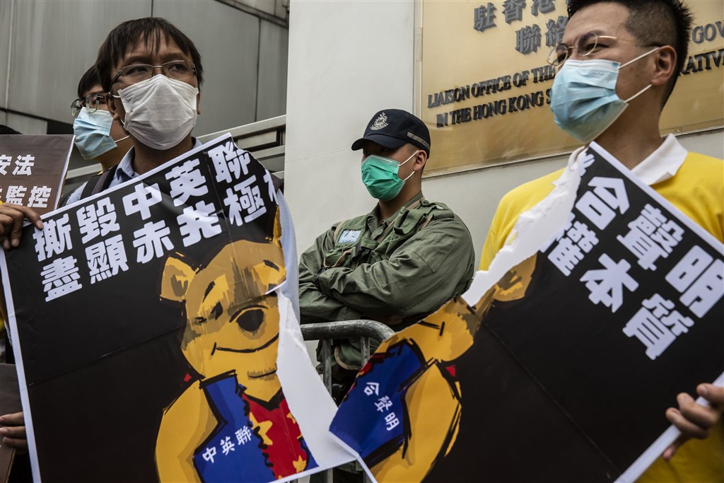 多個泛民政黨24日遊行至中國中央人民政府駐香港特別行政區聯絡辦公室(中聯辦),抗議全國人大審議「港版國安法」的授權立法決定。(法新社提供)