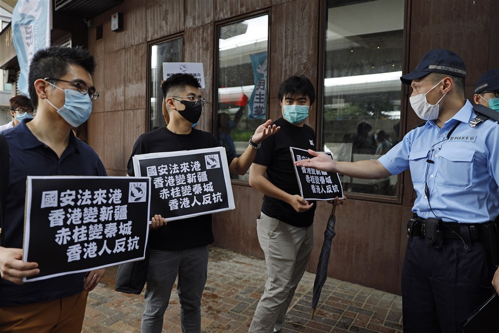 中國全國人大將審議「港版國安法」授權案,引發爭議。圖為香港民主黨22日到中聯辦外抗議港版國安法時,與警察發生爭執。(美聯社)