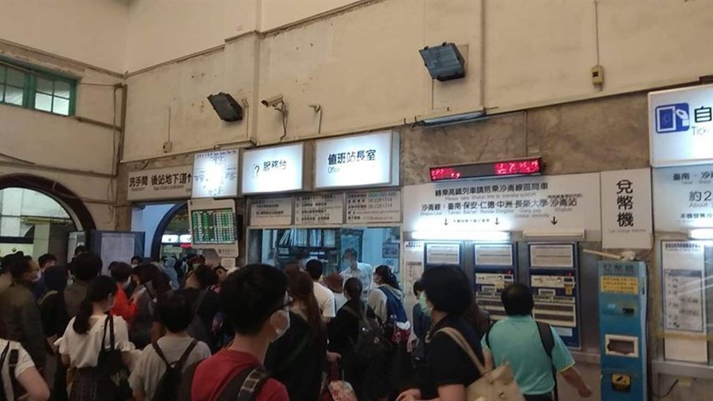 台鐵台南-保安間榮譽路平交道因雨勢導致路基掏空,一度雙線不通。圖為乘客在台南火車站大廳排隊等待。(民眾提供)