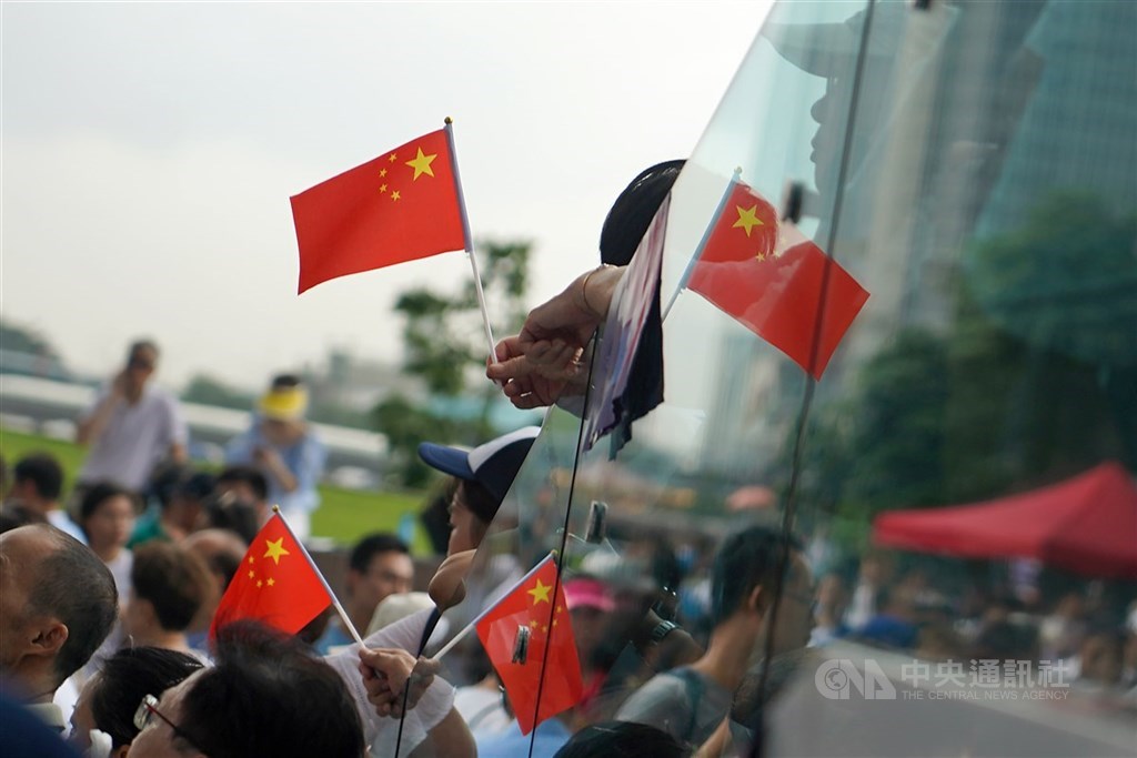香港立法會27日將對國歌條例草案恢復二讀以便實施中國國歌法。圖為2019年反送中運動期間,建制派立法會議員舉辦集會支持港警,參與民眾手持中國國旗表達立場。(中央社檔案照片)