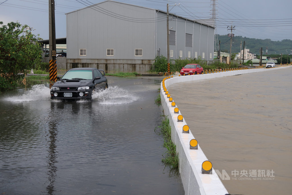 高雄市28日清晨豪雨，岡山區潭底排水也近滿溢，便道積水半個輪胎深，汽車疾駛而過濺起陣陣水花。中央社記者王淑芬攝 109年5月28日