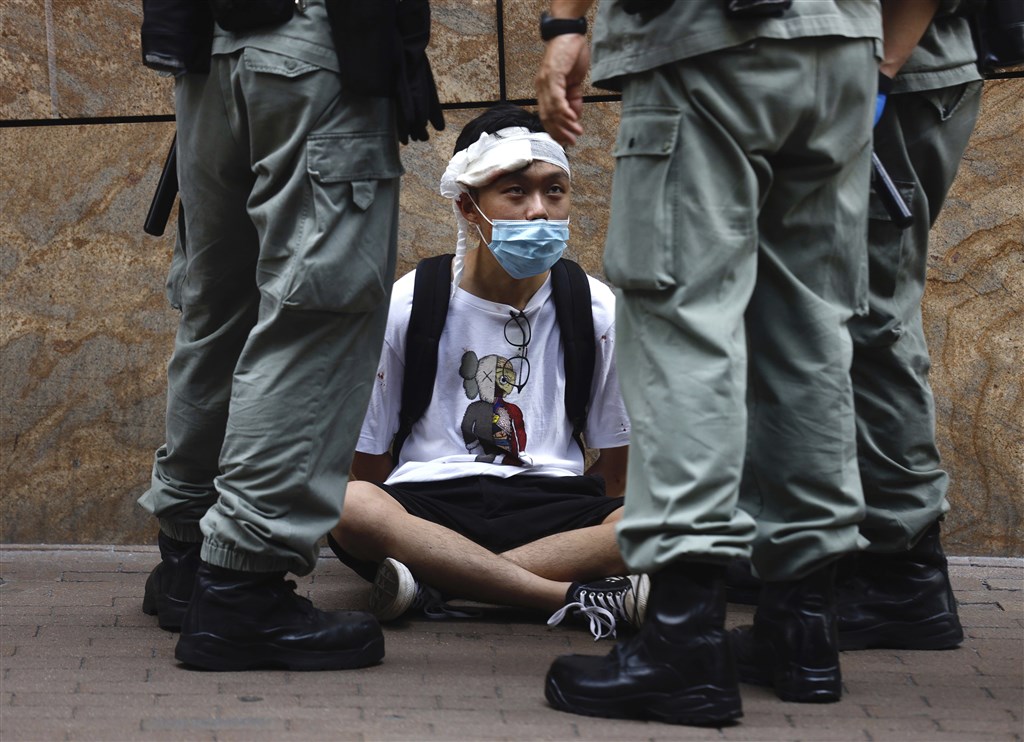 中國企圖推「港版國安法」引發高度爭議,美國國務卿蓬佩奧27日向美國國會認證,香港不再擁有高度自治,因此不再符合美國法律下特殊待遇。圖為香港立法會27日恢復二讀辯論「國歌條例草案」,港警與議會外抗議民眾對峙。(美聯社)