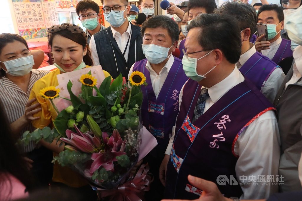 中央流行疫情指揮中心指揮官陳時中(前右2)29日到桃園帶動觀光旅遊景氣,桃園市長鄭文燦(前右)安排到永安漁港體驗在地海鮮及農特產品等,現場熱情民眾獻花向陳時中致意。中央社記者吳家昇攝 109年5月29日