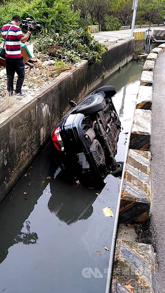 一輛黑色小客車29日行經台中市大雅區中清路四段時,疑因過彎車速過快,失控衝進路旁大排,整輛車身側翻,70歲受困女駕駛命危,送醫搶救中。(民眾提供)中央社記者趙麗妍傳真 109年5月29日