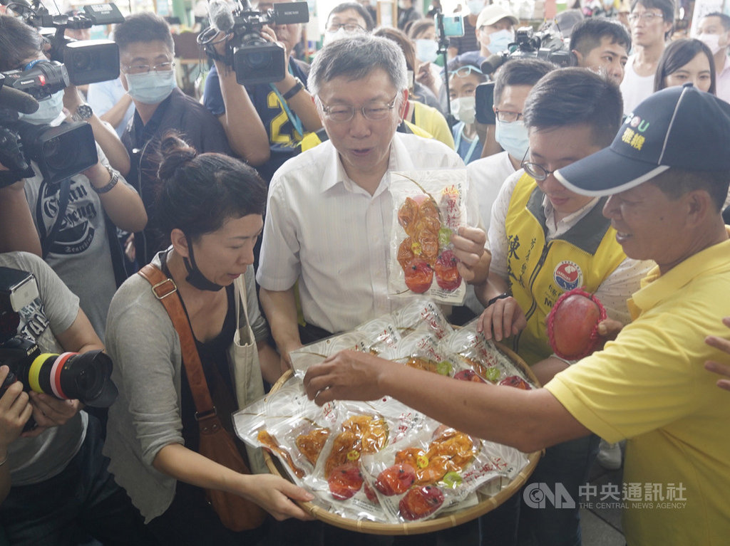台北市長柯文哲(中白衣者)30日到台北花博農民市集出席「枋寮漁菓節」屏東農特產展銷活動,協助宣傳農民產製的芒果乾。中央社記者徐肇昌攝 109年5月30日