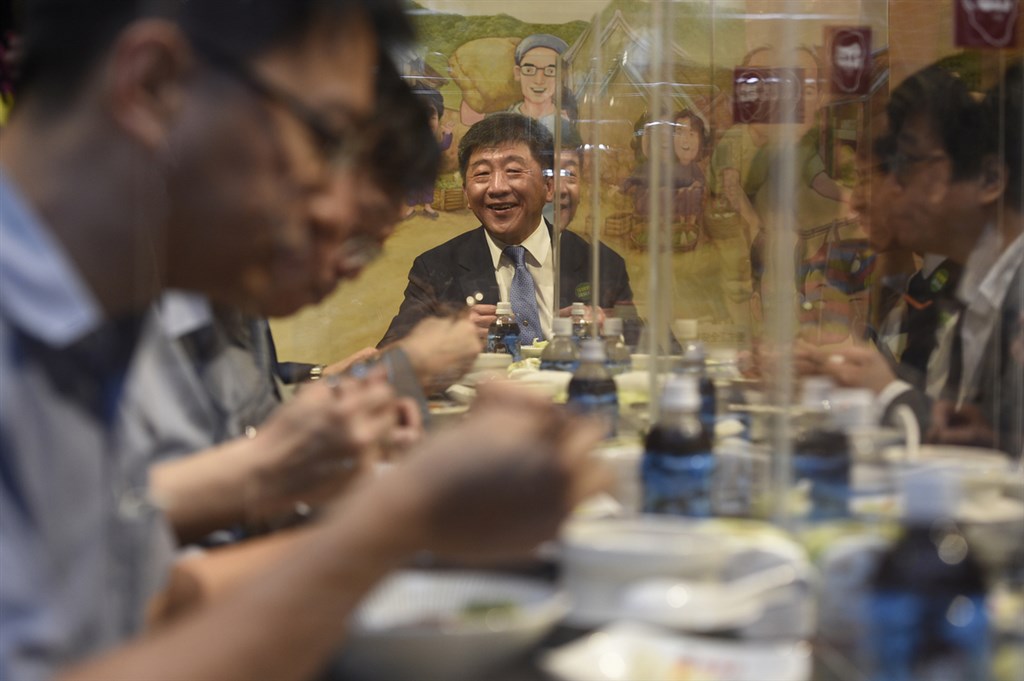 疫情指揮中心指揮官陳時中(中)16日走訪台北市知名餐廳享用滷肉飯,示範「防疫新生活運動」,業者在餐桌設置透明隔板,桌與桌之間也維持適當距離。(台北市攝影記者聯誼會提供)