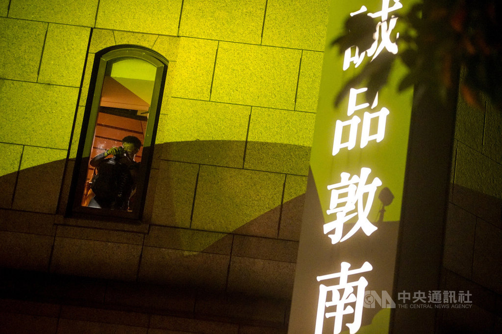 「不打烊書店」誠品敦南店吹熄燈號,31日晚間邀請歌手與樂團在1樓戶外廣場接力開唱,書店內也有民眾在窗口觀看演出。中央社記者裴禛攝 109年5月31日