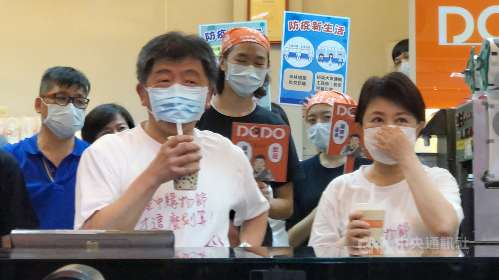 中央流行疫情指揮中心指揮官、衛福部長陳時中(前左)31日下午造訪台中,與台中市長盧秀燕(前右)一同走訪熱鬧商圈,更逗趣「示範」戴著口罩喝珍奶。中央社記者趙麗妍攝 109年5月31日
