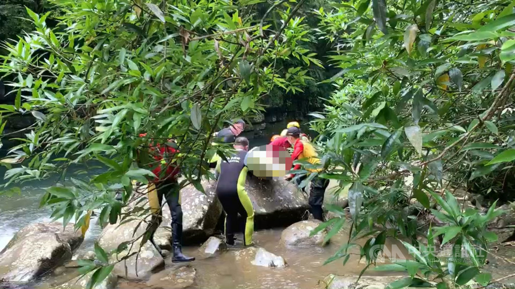 胡姓男子5月30日與家人到新北市雙溪區爬山,女兒拍照時不慎滑落北勢溪,胡男下水救女自己反被溪水沖走,搜救人員6月1日在落水點下方約300公尺處溪中石頭下方尋獲胡男遺體,隨後搬運上岸。(讀者提供)中央社記者王朝鈺傳真 109年6月1日