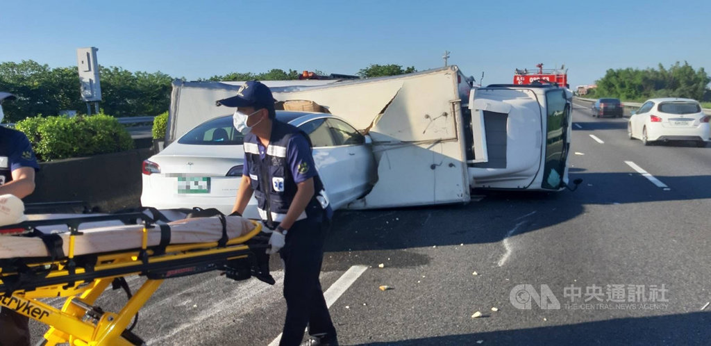 國道1號南下268公里處1日上午發生車禍,一輛貨車在快車道翻覆,後方一台特斯拉剎車不及直接撞進貨車車廂,幸無人傷亡。(嘉義縣消防局提供)中央社記者蔡智明傳真 109年6月1日