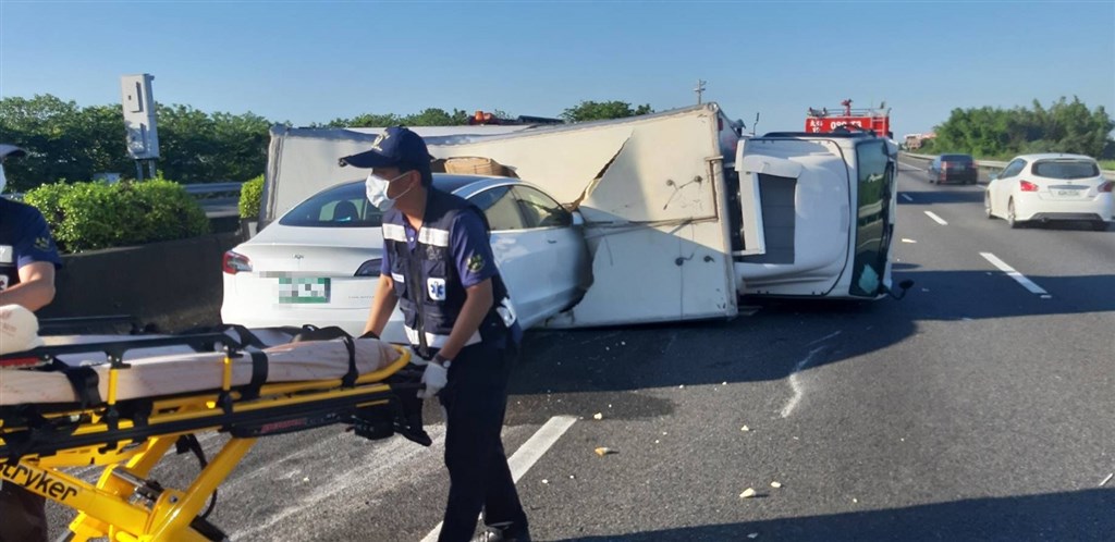 國道1號南下268公里處1日上午發生車禍,一輛貨車在快車道翻覆,後方一台特斯拉剎車不及直接撞進貨車車廂,幸無人傷亡。(嘉義縣消防局提供)中央社記者蔡智明傳真 109年6月1日