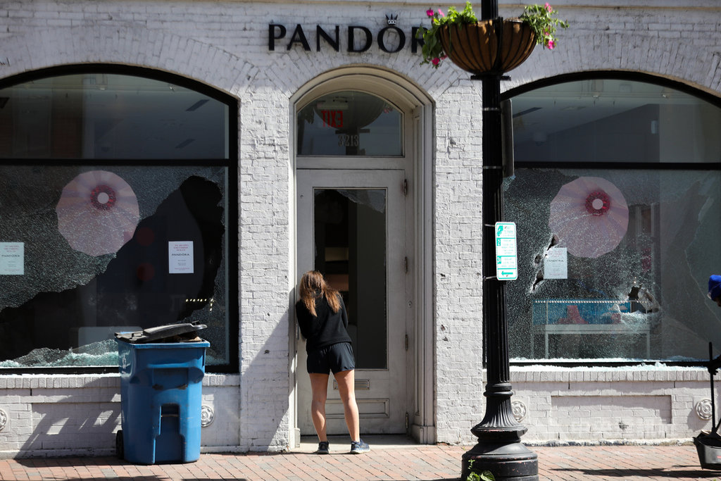 首飾品牌潘朵拉(Pandora)位於華府喬治城的店面,31日晚間疑似遭示威群眾洗劫一空,兩邊櫥窗及大門玻璃都被擊碎。好奇的路過民眾探頭查看店內狀況。中央社記者徐薇婷華盛頓攝 109年6月2日