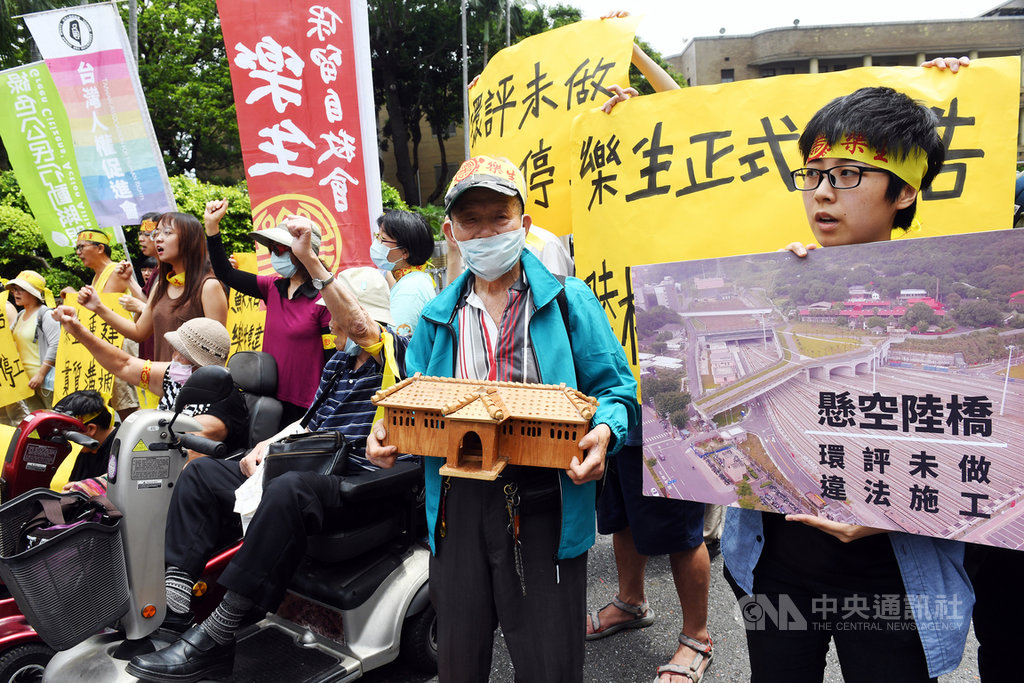 國際愛地芽協會台灣分會、台灣人權促進會等組織團體,2日持看板與布條在行政院大門口前陳情,指樂生園區的懸空陸橋入口景觀工程未作環評,應立即停工。中央社記者施宗暉攝 109年6月2日