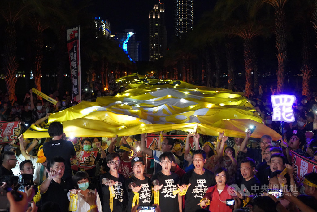 罷韓團體2日持續號召群眾走上街頭,晚間在高雄捷運凹子底站前舉行遊行活動,為6日將登場的高雄市長韓國瑜罷免案催票,眾人合力高舉「波浪黃絲帶民主黃布條」,並點亮手機燈光,展現「堅定罷韓」立場。中央社記者董俊志攝 109年6月2日