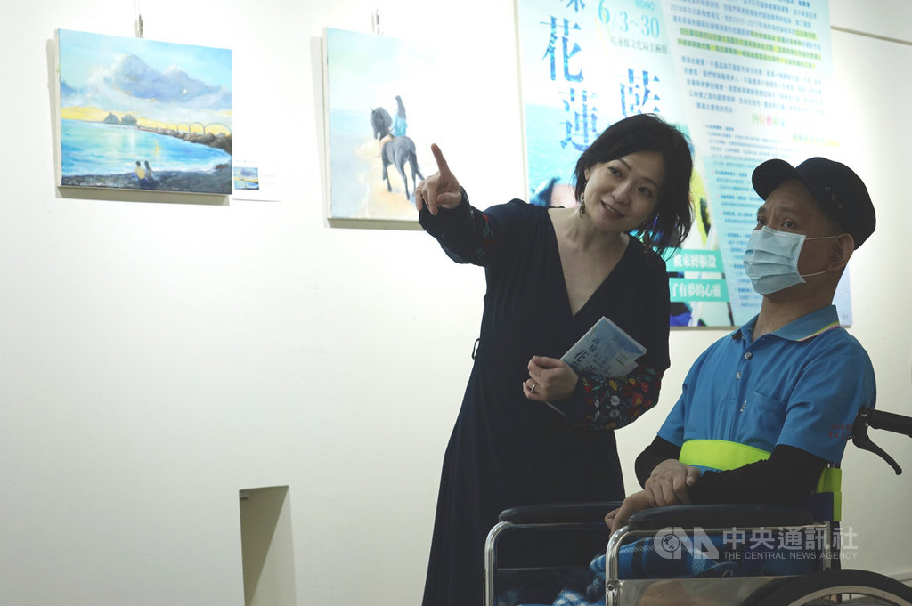 花蓮豐濱鄉民金根鴻(右)因車禍癱瘓,學習用嘴啣筆作畫,3日起回到花蓮辦展,由台灣待用課程協會創辦人之一的陳欣婷(左)協助策展。中央社記者張祈攝 109年6月3日