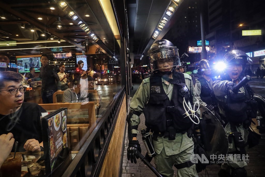 一名消息人士向中央社證實,5名偷渡來台港人確實被扣押,尚未有獲釋消息,但相信處境不至於是被「軟禁」。圖為2019年8月香港人被迫看著警察驅離示威者。(中央社檔案照片)