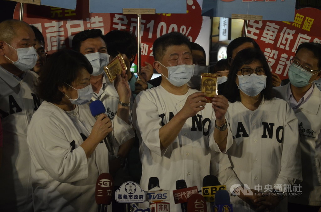 中央流行疫情指揮中心指揮官、衛福部長陳時中(中) ,5日晚逛嘉義市文化路夜市,嘉義市一家煎餅店,特製「防疫5月天」煎餅,烙印著陳時中等人圖案,在文化路展售;陳時中拿著煎餅開玩笑說,「把他吃入心,也要把他的話記牢牢」。中央社記者蔡智明攝 109年6月5日