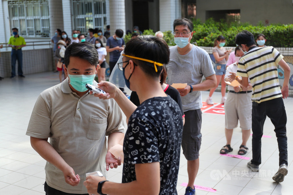 罷韓案投票6日登場,因應防疫需求,民眾須配戴口罩,並配合量測體溫及手部消毒,同時保持社交距離排隊投票。中央社記者吳家昇攝 109年6月6日