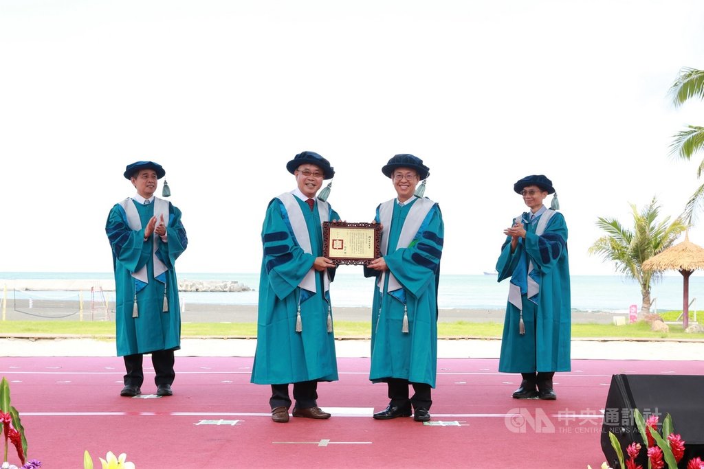 國立中山大學6日在西子灣沙灘舉辦博士班畢業典禮,校長鄭英耀(左2)頒授名譽博士學位給前副總統陳建仁(右2),感謝他在公共衛生環境領域及促進抗疫醫療科技發展方面的貢獻。(中山大學提供) 中央社記者程啟峰傳真 109年6月6日