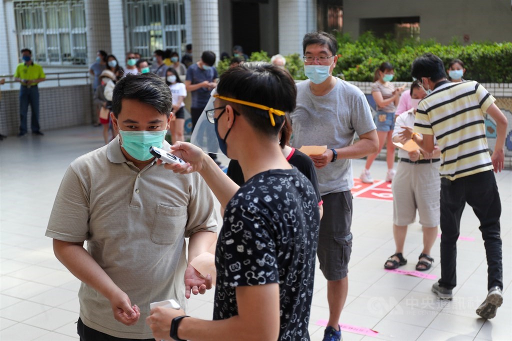 罷韓案投票6日登場,因應防疫需求,民眾須配戴口罩,並配合量測體溫及手部消毒,同時保持社交距離排隊投票。中央社記者吳家昇攝 109年6月6日
