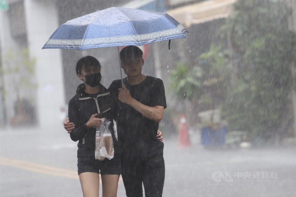 受西南風及午後對流雲系發展旺盛影響,中央氣象局6日發布高雄市等15縣市大雨特報。圖為走在高雄街頭的民眾撐傘避雨。中央社記者吳家昇攝 109年6月6日