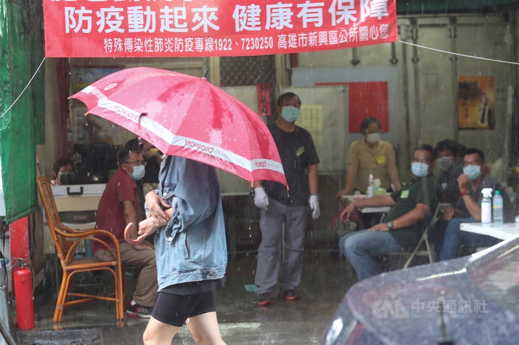 受西南風及午後對流雲系發展旺盛影響,中央氣象局預測6日各地山區及基隆北海岸、宜蘭、南投、南部地區有局部大雨,發布高雄市等15縣市大雨特報。圖為高雄民眾撐傘經過投開票所。中央社記者吳家昇攝 109年6月6日