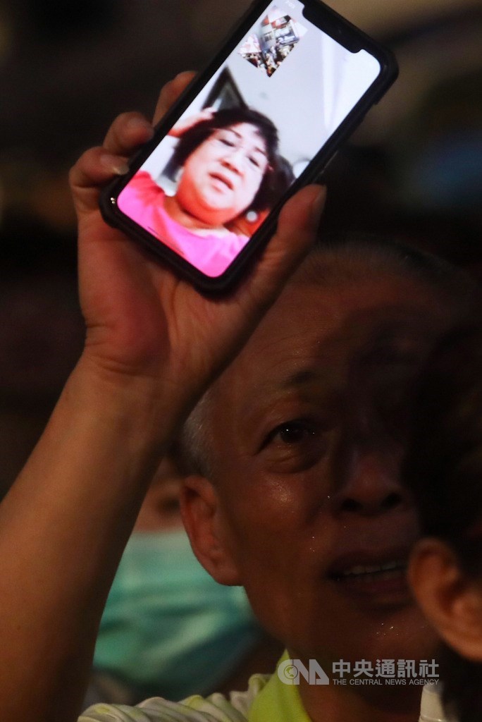 高雄市長韓國瑜罷免案6日高票過關,高雄市民成功寫下歷史,讓韓國瑜成為台灣史上首名遭罷免市長,「光復高雄」總部外,有民眾特別以視訊和無法到場的親人分享好消息。中央社記者吳家昇攝 109年6月6日
