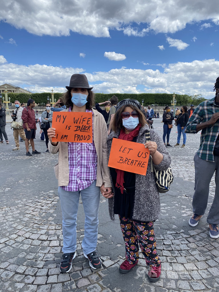 民眾克里斯手持「我的妻子是非裔,我很驕傲」,與妻子多米尼克牽手站在人群中。多米尼克強調,集會目的是要為了世界上所有的佛洛伊德,對抗社會不公義與種族歧視。中央社記者曾婷瑄巴黎攝 109年6月7日