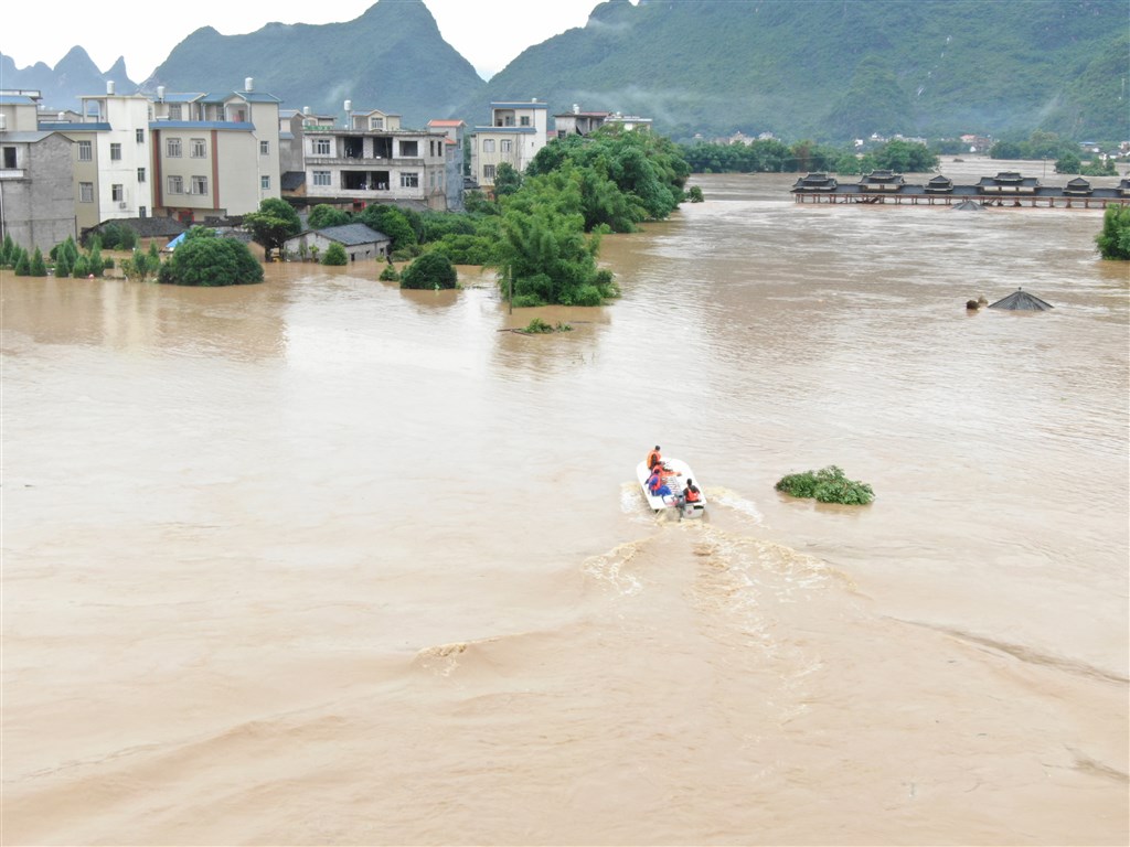 豪雨持續肆虐中國南方各省區,7日廣西桂林市已有多地遭洪害,消防人員乘橡皮艇搜救。(中新社提供)