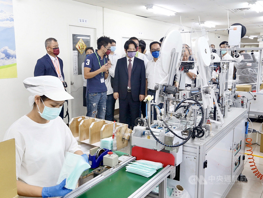 副總統賴清德(中著西裝者)12日南下走訪口罩國家隊高雄淨新科技公司的工廠產線,了解自動化生產口罩過程,也詢問每天口罩產能。中央社記者董俊志攝 109年6月12日