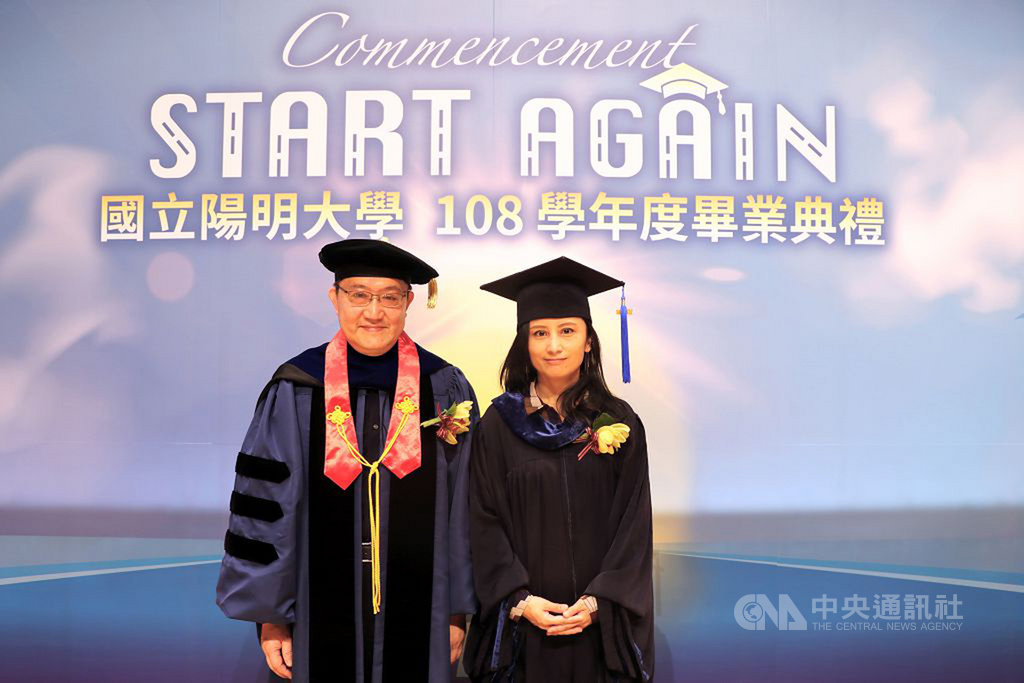 陽明大學13日辦畢業典禮,公元2003年因嚴重急性呼吸道症候群(SARS)疫情而無法參加畢業典禮的校友、振興醫院急診重症醫學部醫師田知學(右)代表上台接受「補撥穗」,與校長郭旭崧(左)合影。(陽明大學提供)中央社記者陳至中台北傳真 109年6月13日