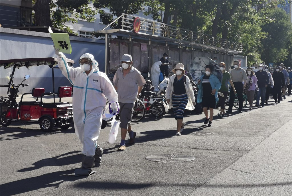北京市14日下午宣布,全市凌晨0時至早上7時又新增8例武漢肺炎確診病例。圖為14日北京市民列隊至一處體育館接受採檢。(中新社提供)