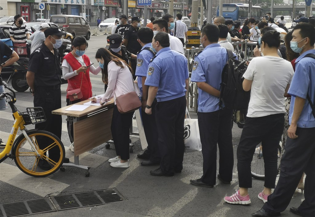 為防武漢肺炎疫情持續擴散,中國北京市16日晚上將突發應變調升至二級,並祭出「半封城」措施,所有小區全面實施封閉式管理。圖為北京一處社區出入口民眾登記情形。(中新社提供)