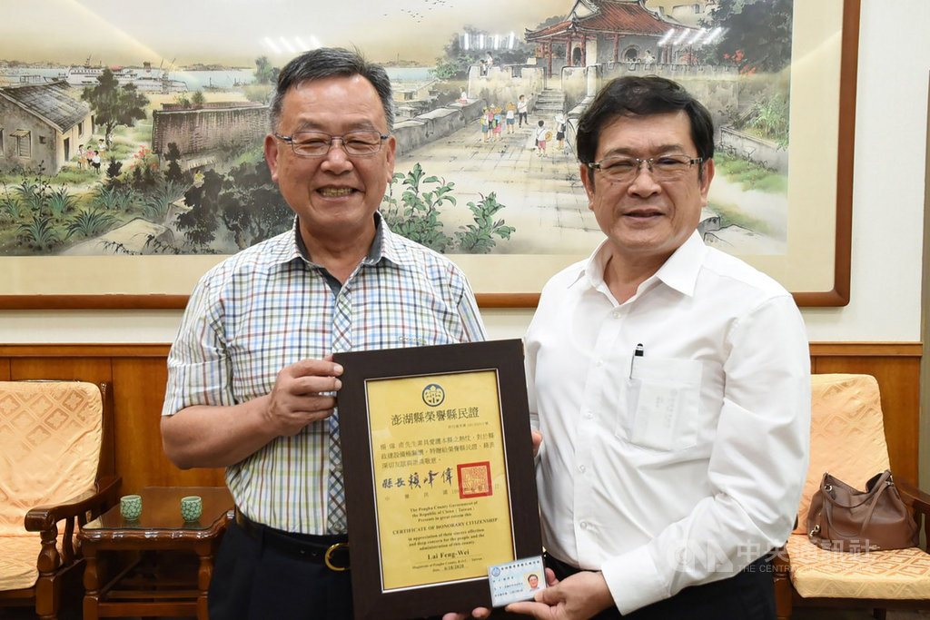 澎湖縣長賴峰偉(左)18日頒贈台電董事長楊偉甫(右)榮譽縣民證,感謝台電公司服務偏鄉離島。(澎湖縣政府提供)中央社 109年6月18日