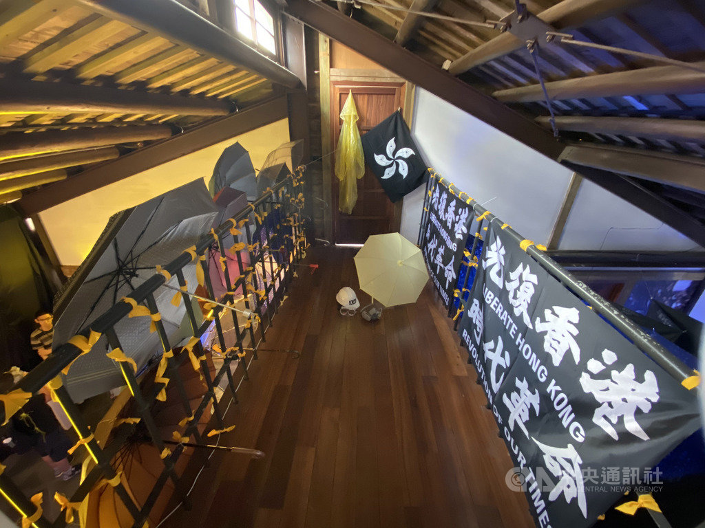 邊城青年籌劃主辦的「穿石 Surmount/香港騷動年代—抗志」展覽20日開幕,使用雨傘、防毒面具等道具,模擬去年香港「反送中」運動的街頭抗爭場景。中央社記者賴言曦攝 109年6月20日