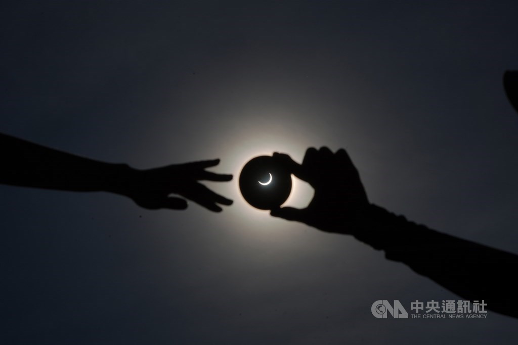 天文盛事日環食21日下午登場，台灣本島下午2時48分起陸續進入日食可見範圍內。民眾在台中高美濕地觀測日環食，並玩戴戒指的梗。中央社記者徐肇昌攝　109年6月21日